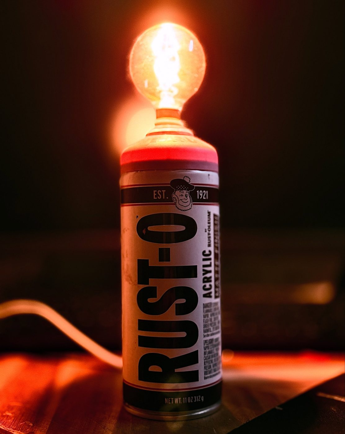Rust-Oleum spray can lamp topped with a glowing round filament bulb